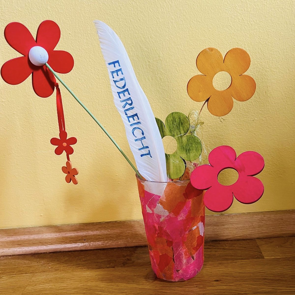 Fahne mit dem Wort Federleicht und Blumen in einem Becher